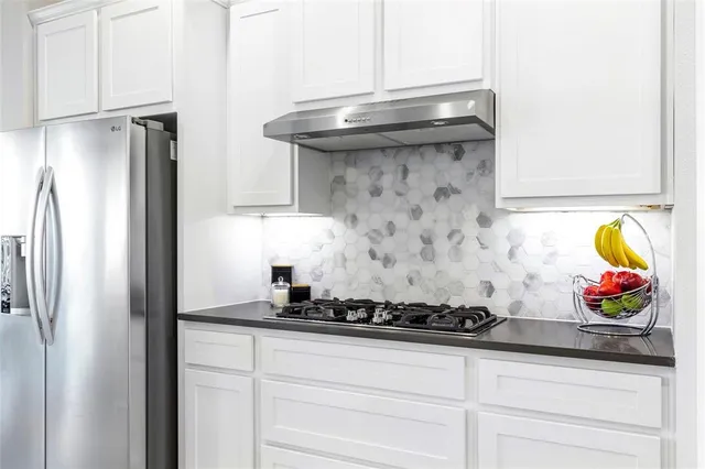 a kitchen with stainless steel appliances granite countertop a refrigerator and a stove