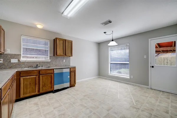 a large kitchen with stainless steel appliances granite countertop a sink dishwasher stove and cabinets