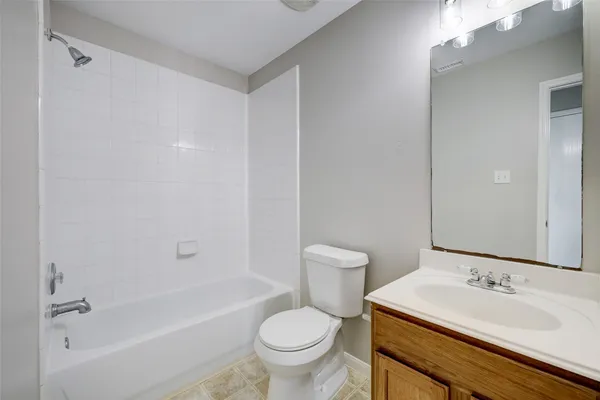a bathroom with a granite countertop sink a toilet and a bathtub