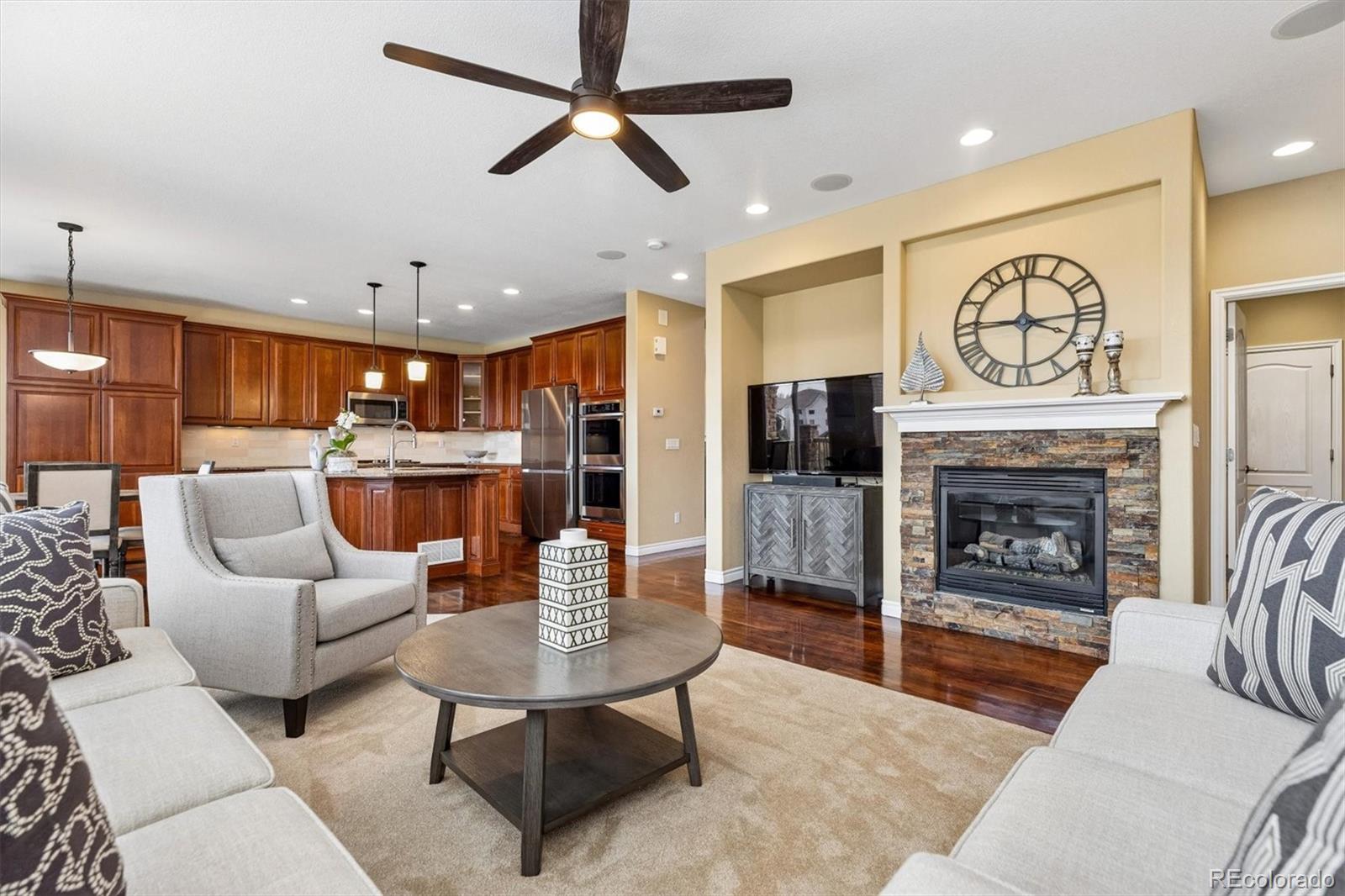 11025 Grayledge Circle Highlands Ranch, CO 80130 - Photo 14 of 46 a living room with furniture a fireplace and a ceiling fan
