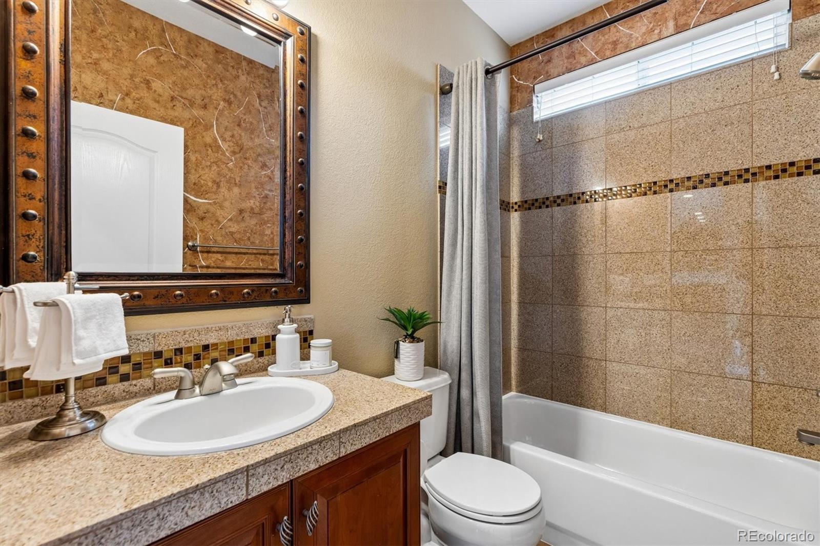 11025 Grayledge Circle Highlands Ranch, CO 80130 - Photo 16 of 46 a bathroom with a granite countertop sink toilet mirror and shower