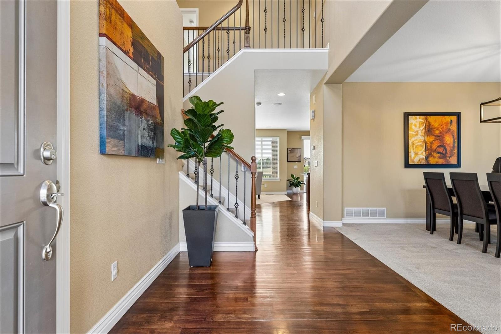 11025 Grayledge Circle Highlands Ranch, CO 80130 - Photo 2 of 46 a view of a hallway with wooden floor and stairs