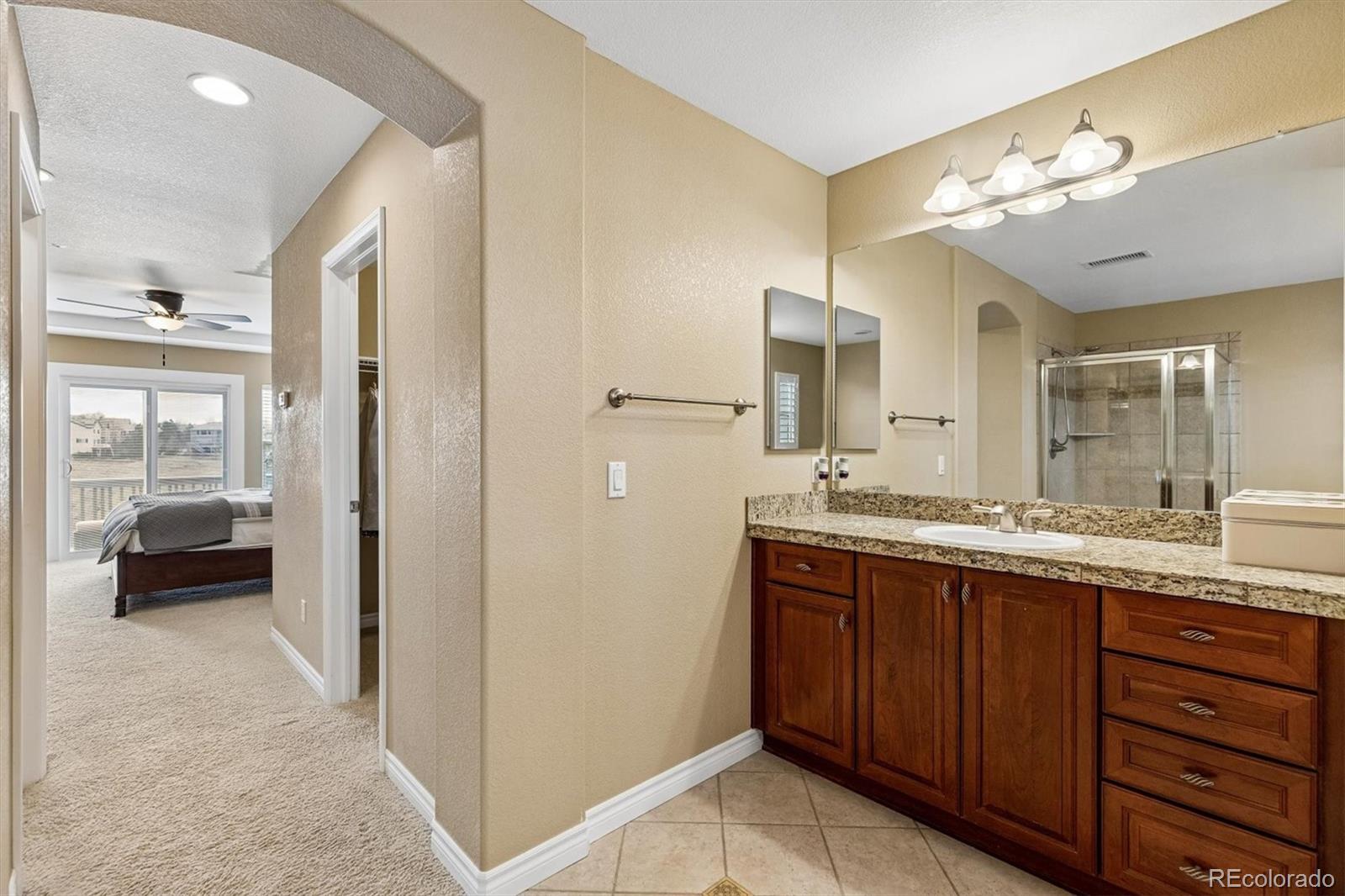 11025 Grayledge Circle Highlands Ranch, CO 80130 - Photo 21 of 46 a spacious bathroom with a granite countertop sink mirror and a