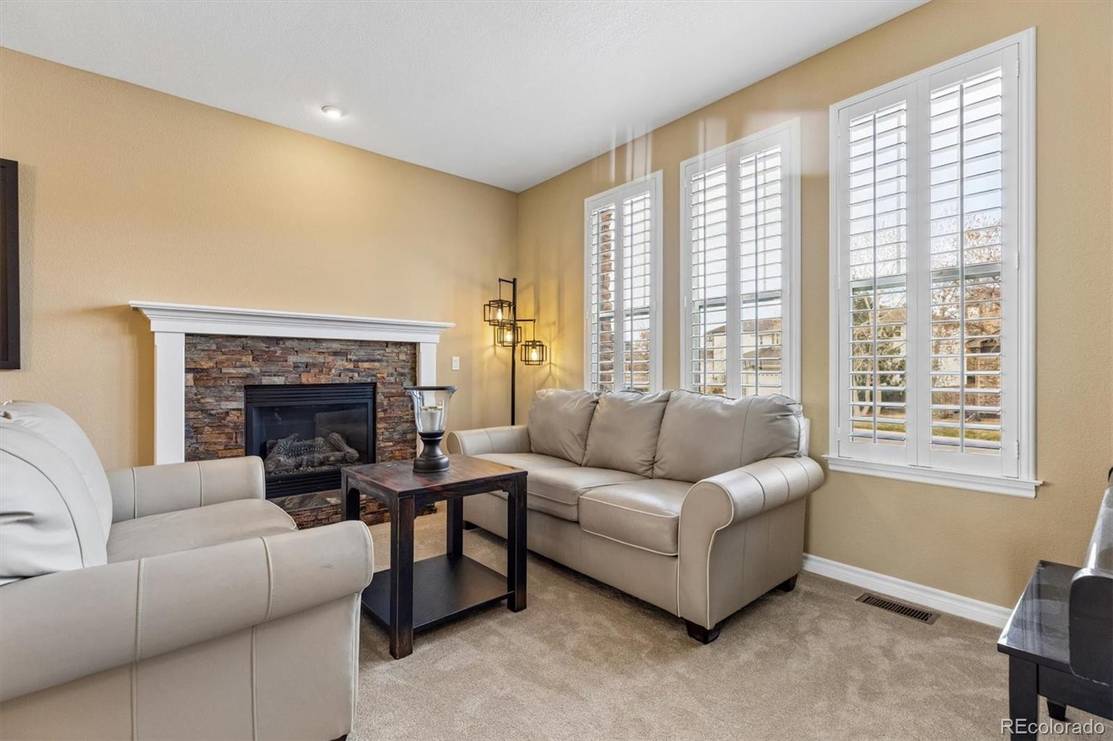 11025 Grayledge Circle Highlands Ranch, CO 80130 - Photo 5 of 46 a living room with furniture and a fireplace