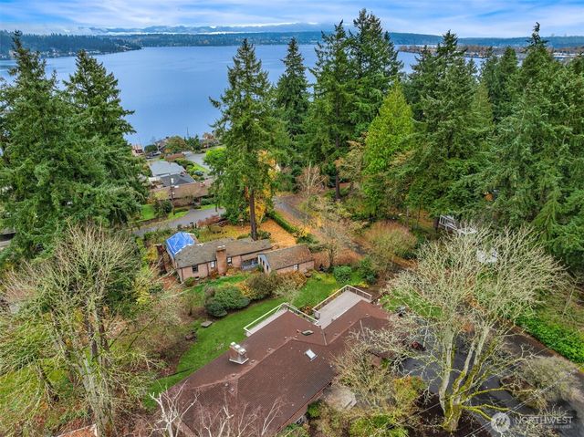 an aerial view of a house with a yard and lake view