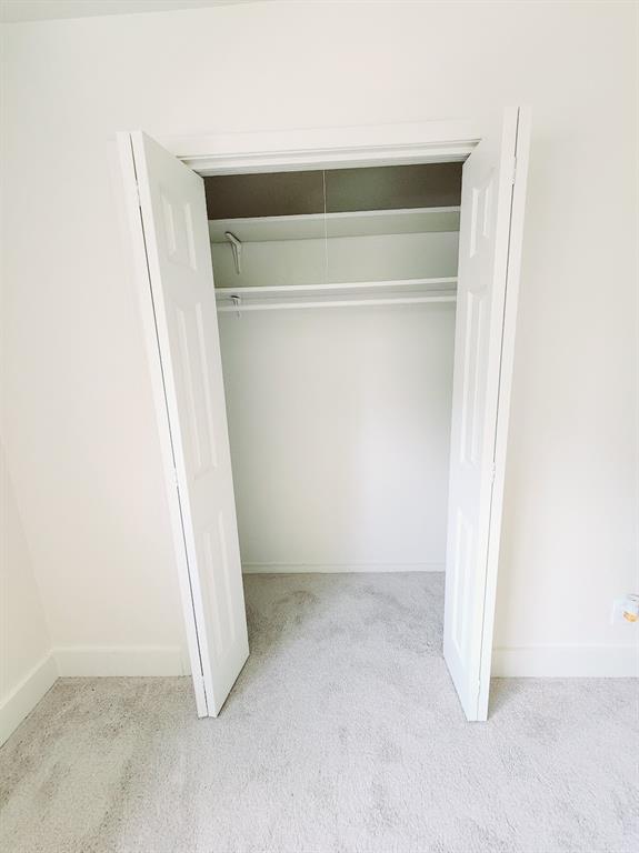 2908 Washington Street Commerce, TX 75428 - Photo 26 of 29 Bifold closet doors revealing a spacious interior with shelving and a hanging rod