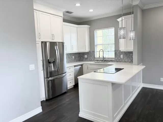 a kitchen with refrigerator cabinets and wooden floor