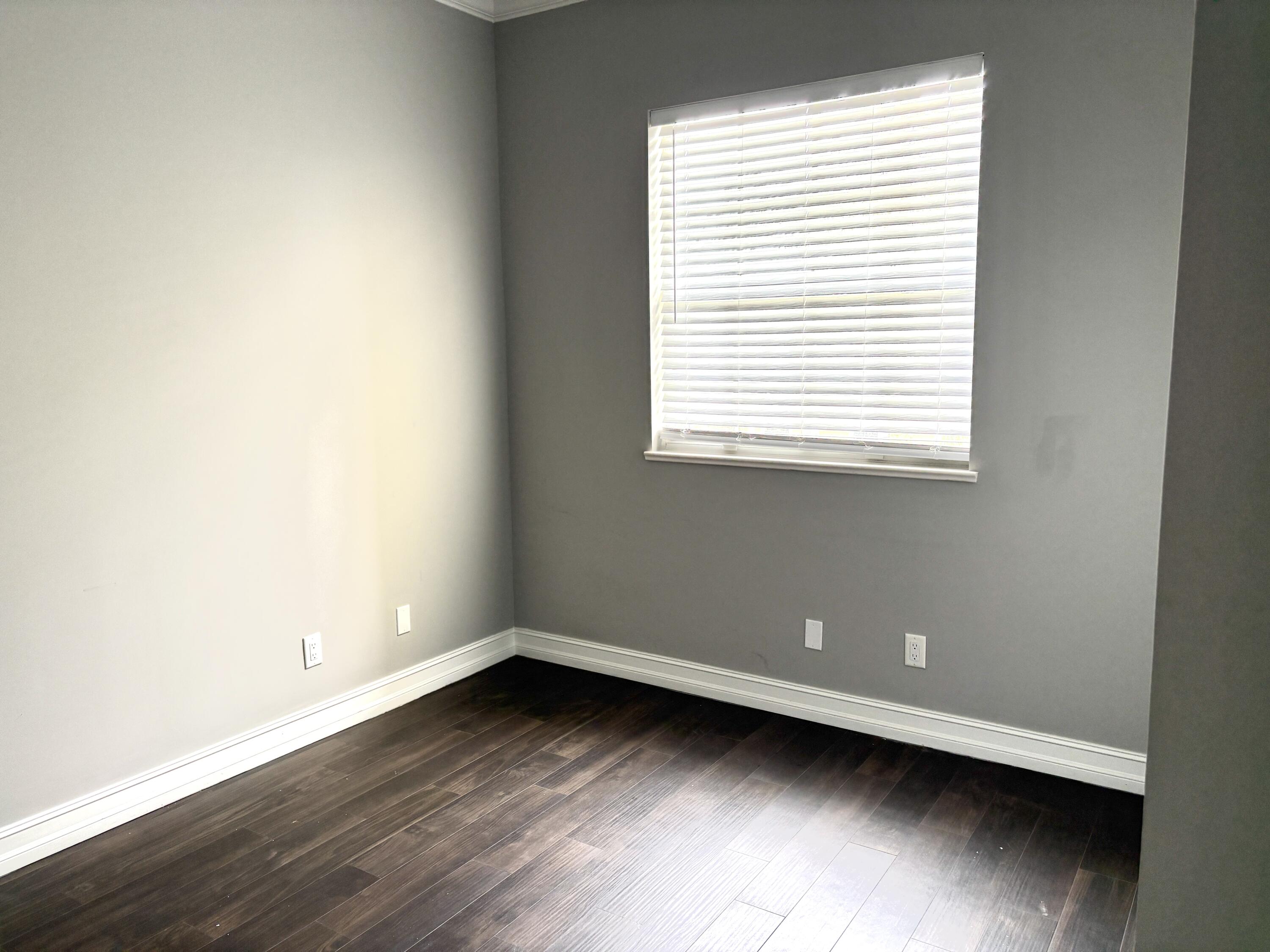 10560 Southwest Stephanie Way, Unit 1202 Port St. Lucie, FL 34987 - Photo 19 of 19 a view of an empty room with wooden floor and a window