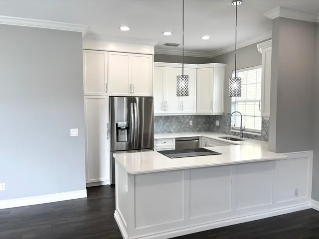 a kitchen with stainless steel appliances granite countertop a refrigerator a sink and a stove