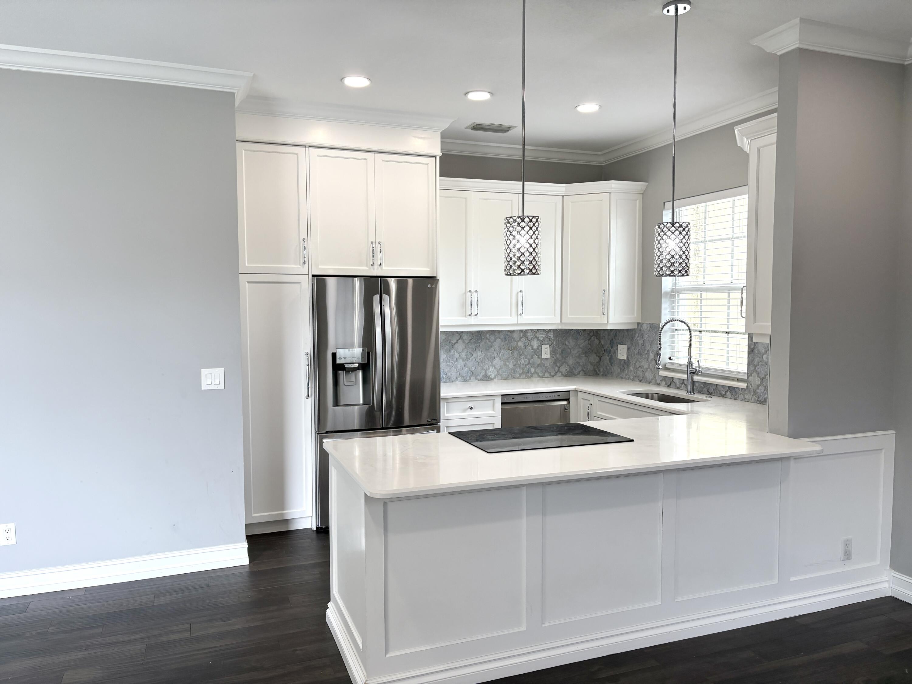 10560 Southwest Stephanie Way, Unit 1202 Port St. Lucie, FL 34987 - Photo 5 of 19 a kitchen with stainless steel appliances granite countertop a refrigerator a sink and a stove