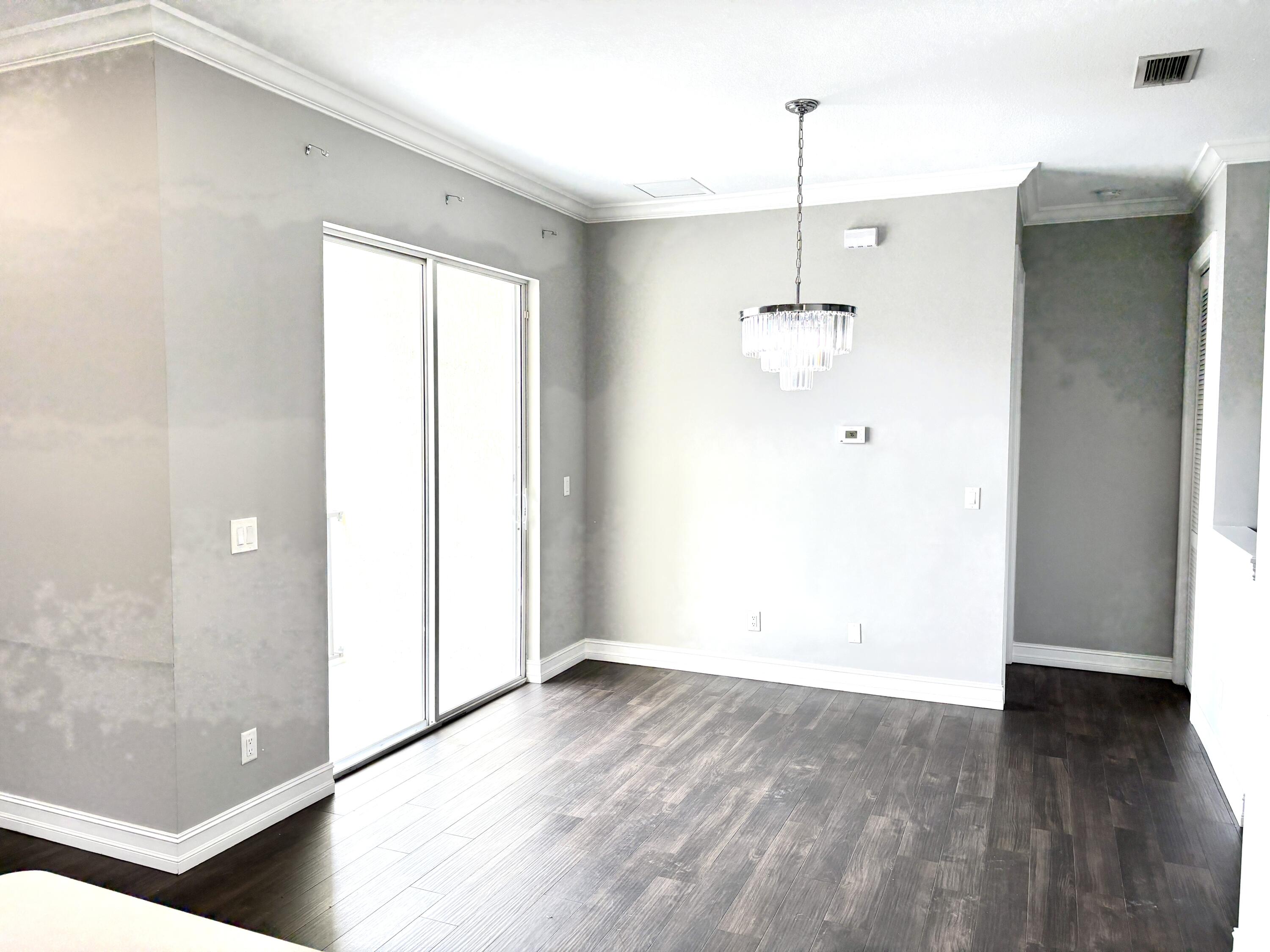 10560 Southwest Stephanie Way, Unit 1202 Port St. Lucie, FL 34987 - Photo 7 of 19 an empty room with wooden floor and windows