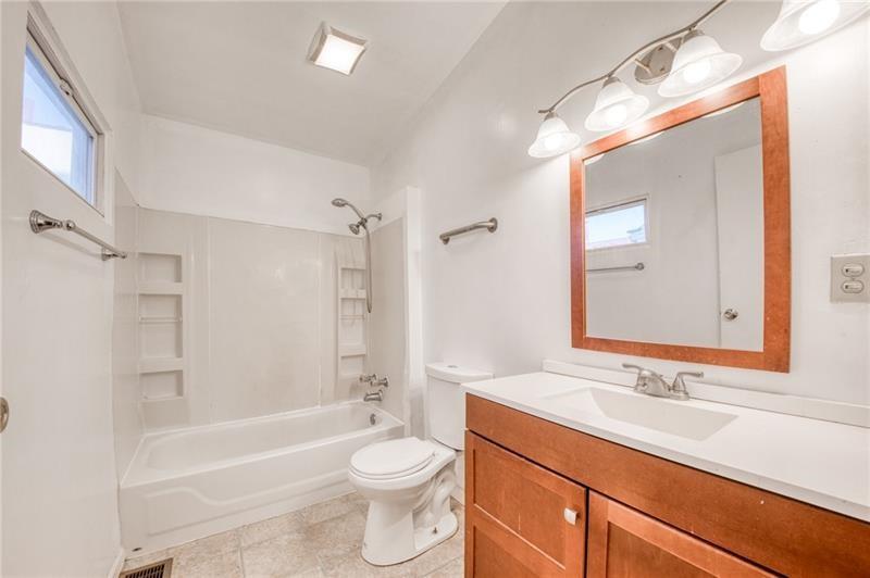 65 South 14th Street Pittsburgh, PA 15203 - Photo 14 of 24 a bathroom with a sink a toilet a mirror a bathtub and shower