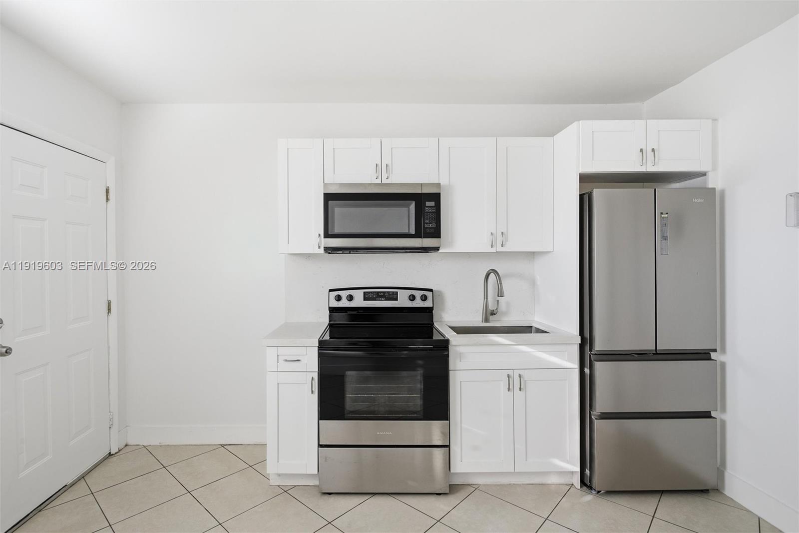 2445 Southwest 18th Street, Unit 3 Miami, FL 33145 - Photo 3 of 18 a kitchen with white cabinets and stainless steel appliances