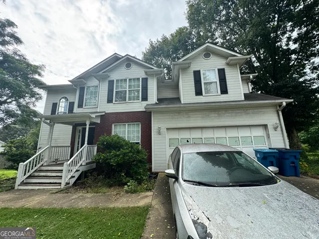 a front view of a house with a garden and plants