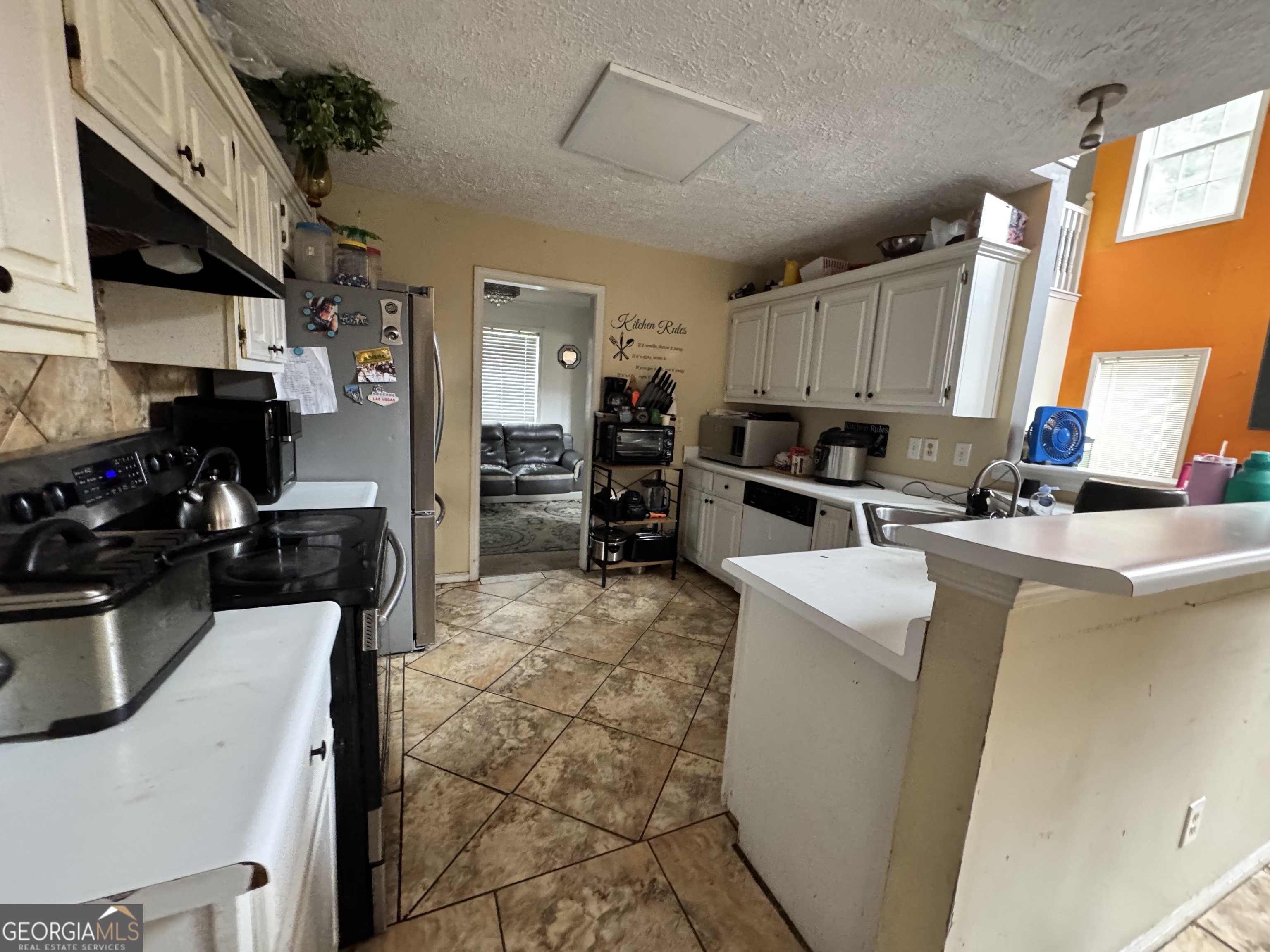 2487 Courtney Renea Drive Dacula, GA 30019 - Photo 8 of 16 a kitchen with stainless steel appliances a stove a sink a microwave a refrigerator and cabinets