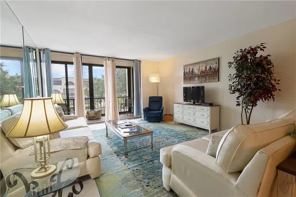 a living room with furniture a lamp and a potted plant