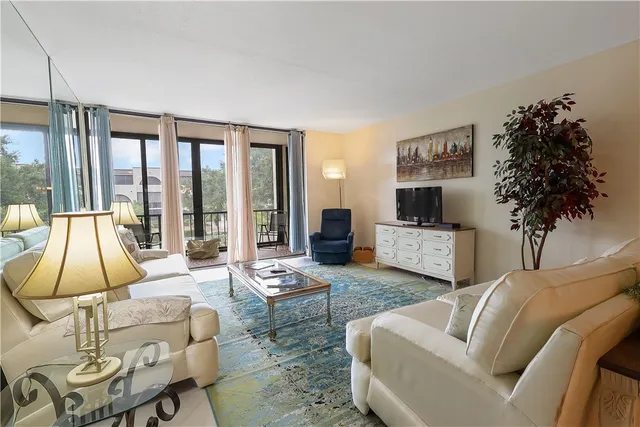 a living room with furniture a lamp and a potted plant