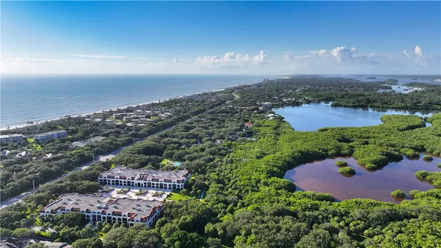an aerial view of residential houses with outdoor space and trees