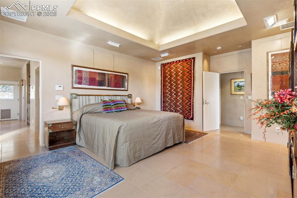 99 Bradburn Road Cotopaxi, CO 81223 - Photo 32 of 49 a bedroom with a large bed and a chandelier