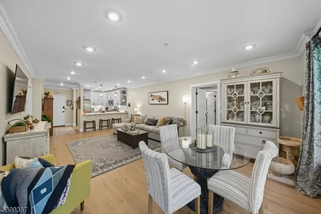 a living room with furniture kitchen view and a large window