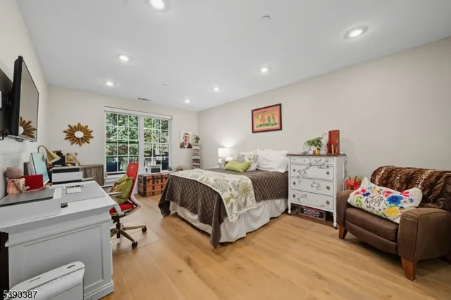 a spacious bedroom with a bed a couch and a flat screen tv