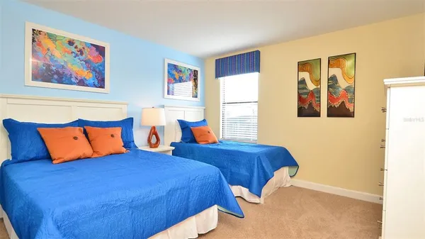 a bedroom with two beds and painting on the wall