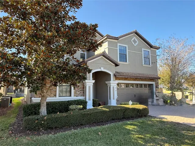 a front view of a house with a garden and trees