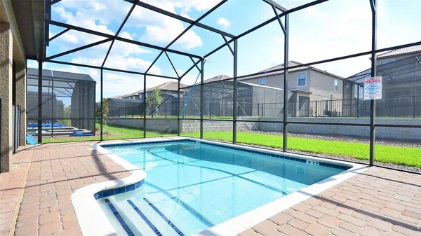 a view of a swimming pool with a lawn chairs next to yard