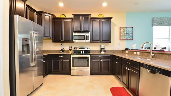 a kitchen with stainless steel appliances granite countertop a refrigerator stove and sink