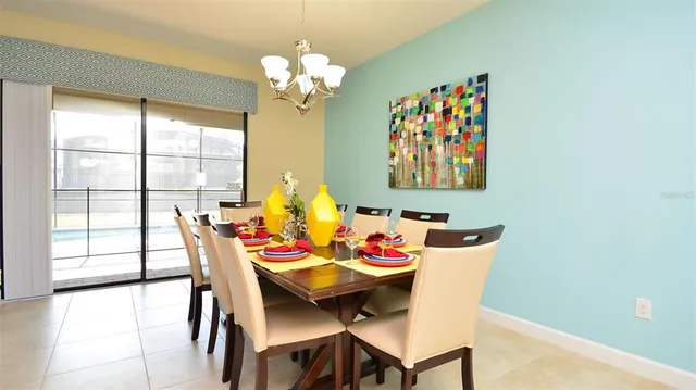 a view of a dining room with furniture a chandelier and wooden floor