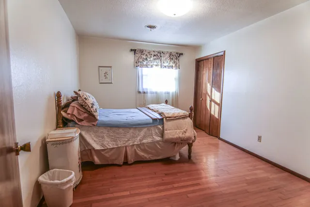 a bedroom with a bed and wooden floor
