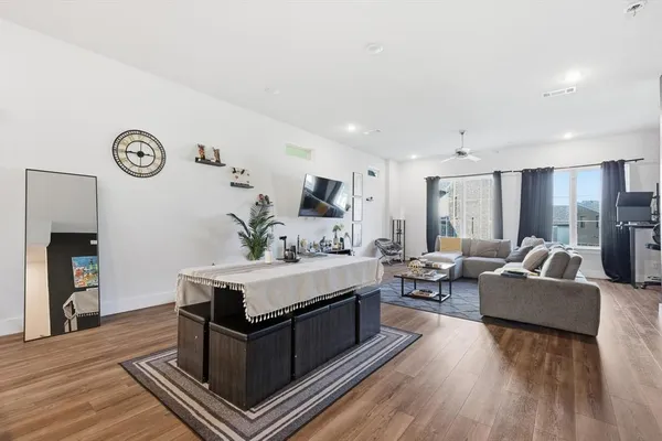 a living room with furniture and a wooden floor