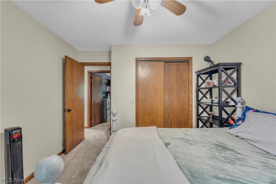 408 River Road Canal Fulton, OH 44614 - Photo 27 of 42 Room featuring neutral wall paint, carpet flooring, a ceiling fan with light fixture, and a wood-finish closet with sliding doors