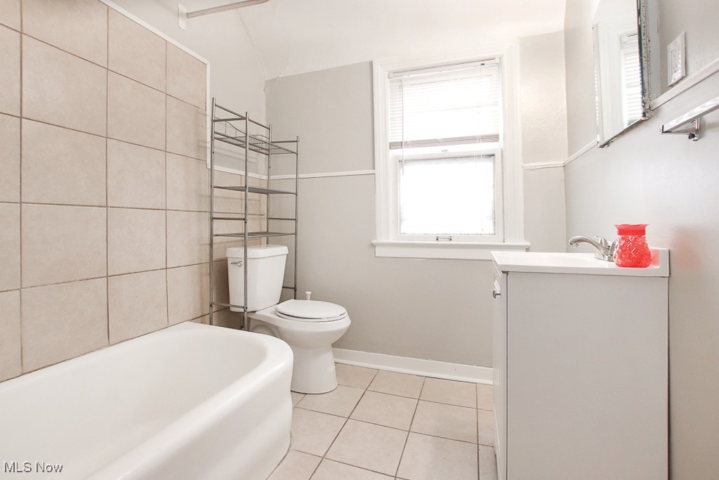 3973 Navahoe Road Cleveland, OH 44121 - Photo 8 of 14 Bathroom with tile patterned floors, toilet, a bathing tub, baseboards, and vanity