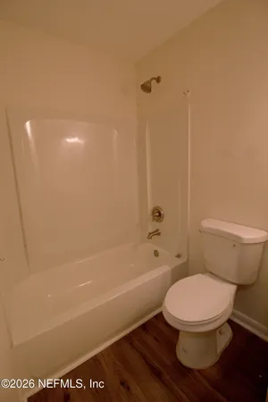 a white toilet sitting next to a bath tub and a shower