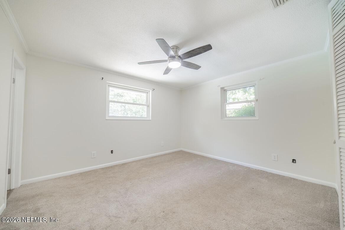 7762 Knoll Drive South Jacksonville, FL 32221 - Photo 15 of 22 an empty room with a window and a fan