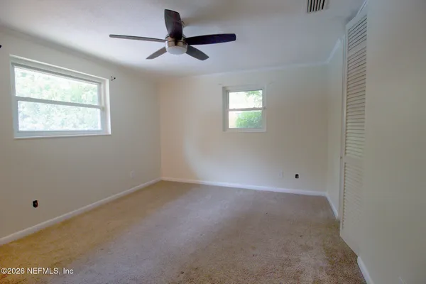 an empty room with a window and a fan