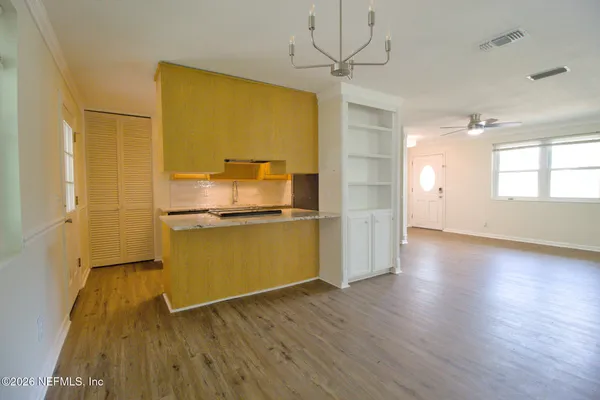 a view of a kitchen with wooden floor a sink and a refrigerator