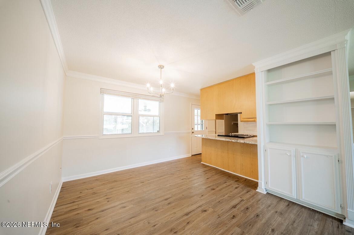 7762 Knoll Drive South Jacksonville, FL 32221 - Photo 8 of 22 a kitchen with a wooden floor and a window