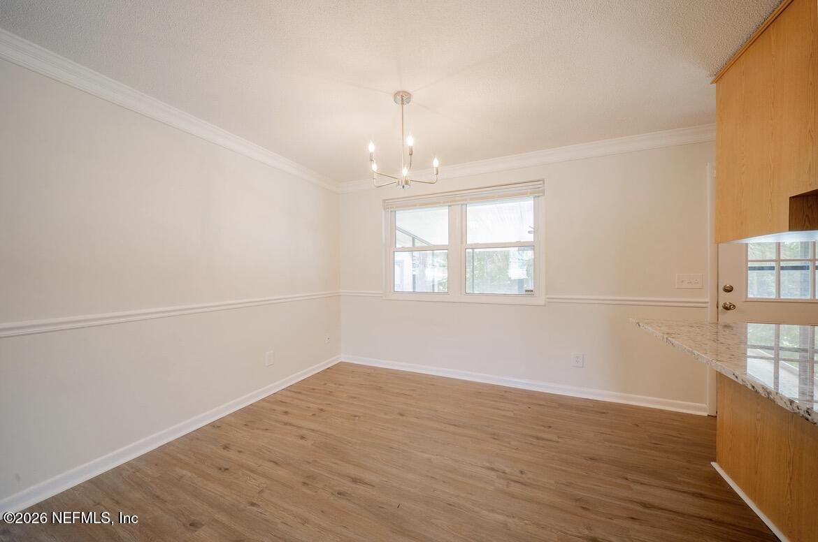 7762 Knoll Drive South Jacksonville, FL 32221 - Photo 9 of 22 wooden floor in an empty room with a window