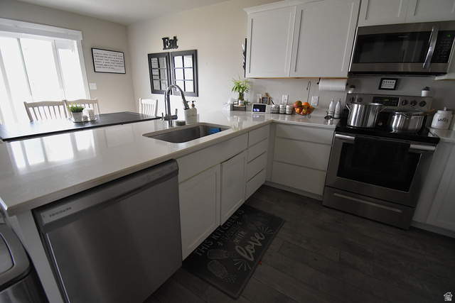 1688 West 200 North Mapleton, UT 84664 - Photo 5 of 18 Kitchen with stainless steel appliances, a peninsula, dark wood-type flooring, white cabinets, and light stone counters