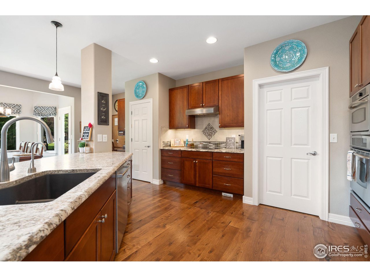 6523 Aberdour Circle Windsor, CO 80550 - Photo 11 of 40 a kitchen with kitchen island granite countertop a sink cabinets and stainless steel appliances