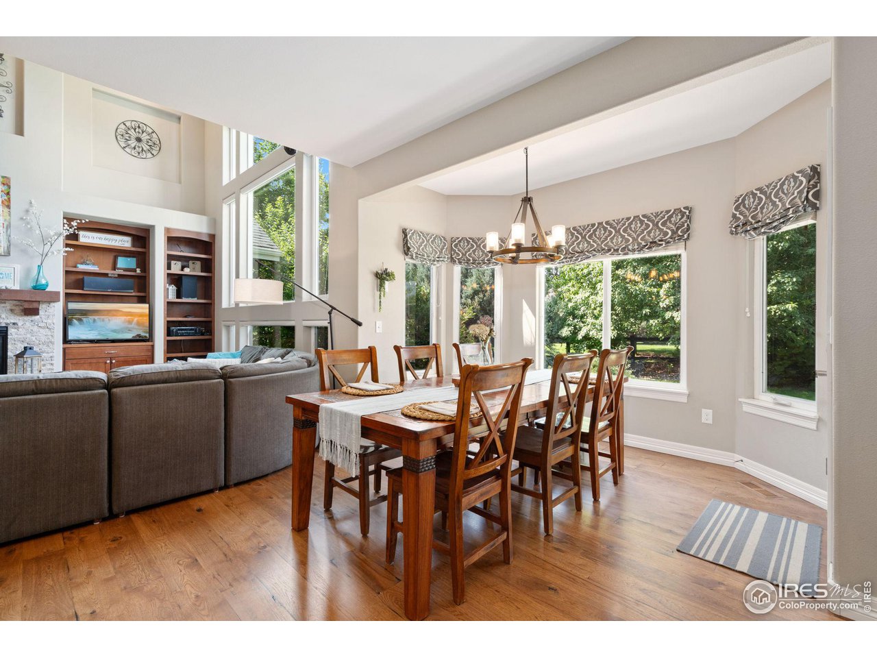 6523 Aberdour Circle Windsor, CO 80550 - Photo 13 of 40 a dining room with furniture a chandelier and wooden floor