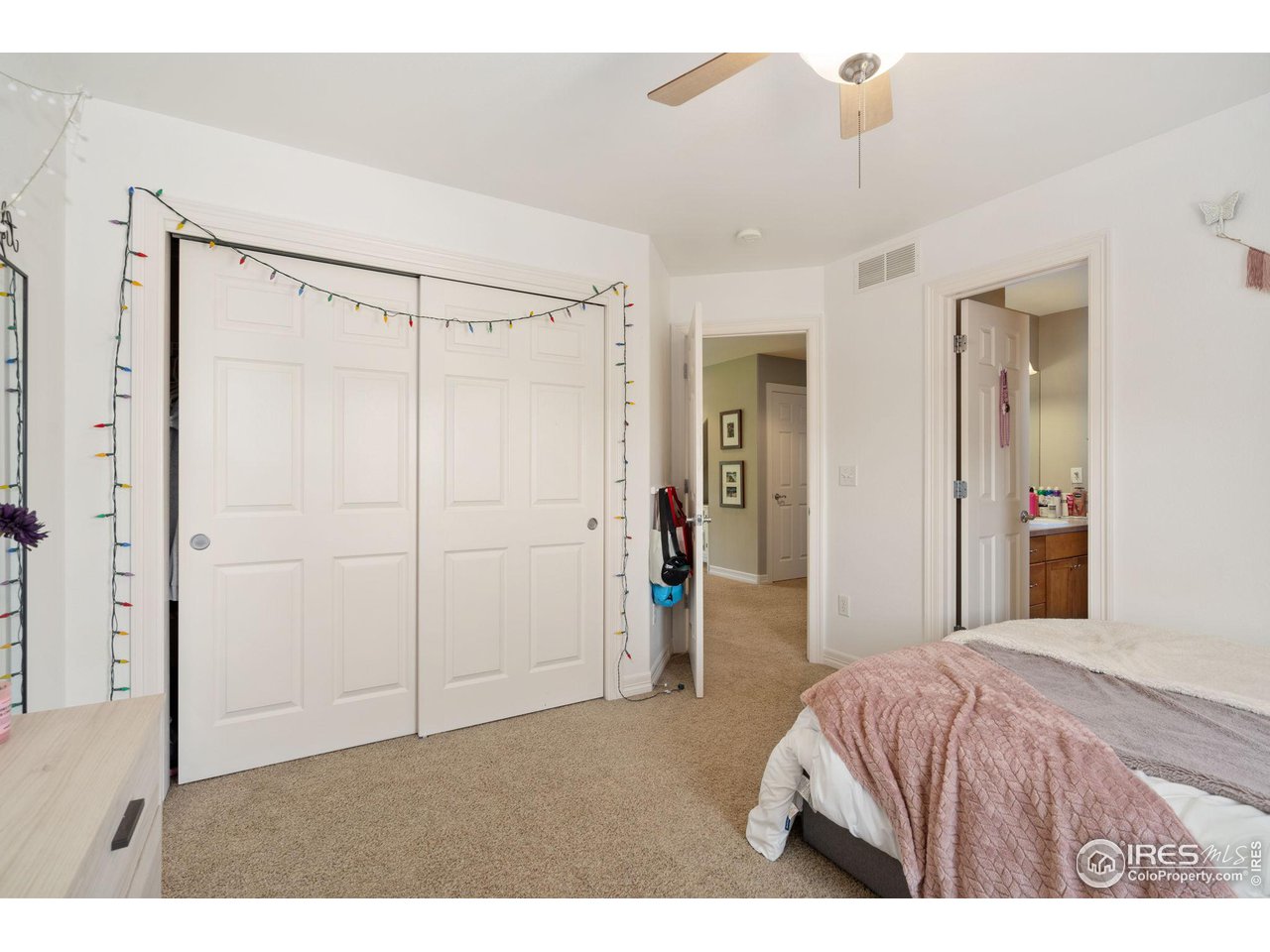 6523 Aberdour Circle Windsor, CO 80550 - Photo 21 of 40 a bedroom with a bed and a chandelier