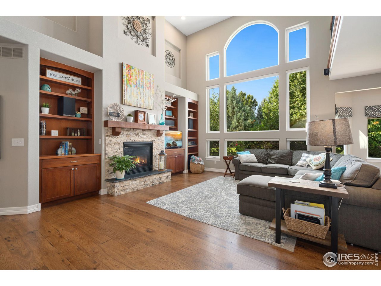 6523 Aberdour Circle Windsor, CO 80550 - Photo 6 of 40 a living room with furniture a fireplace and a large window