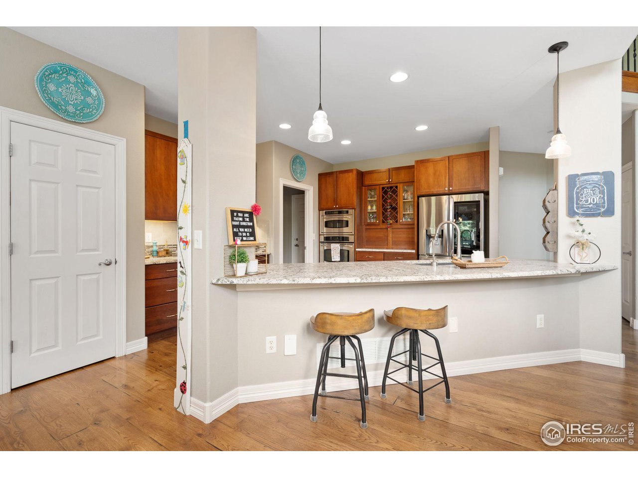 6523 Aberdour Circle Windsor, CO 80550 - Photo 9 of 40 a kitchen with stainless steel appliances granite countertop a kitchen island a stove a cabinets and a wooden floor