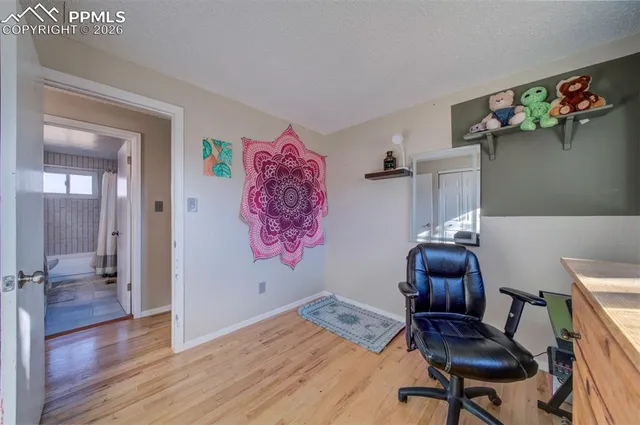 a view of a workspace with furniture and wooden floor