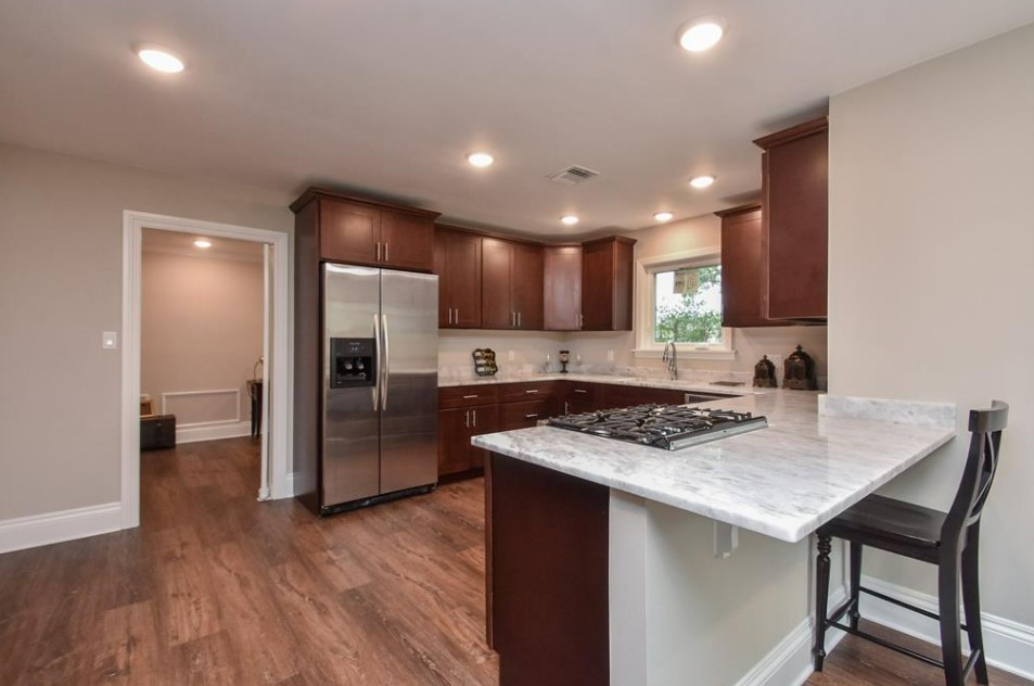 1506 10th Street Hempstead, TX 77445 - Photo 12 of 31 a kitchen with a stove a refrigerator and a wooden cabinets