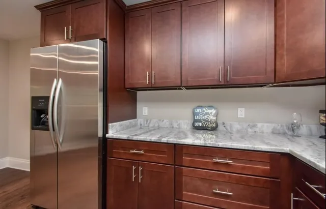 a kitchen with granite countertop stainless steel appliances refrigerator and cabinets