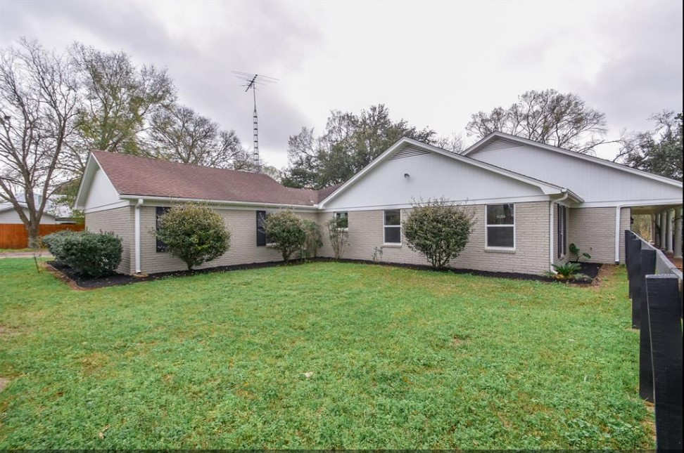 1506 10th Street Hempstead, TX 77445 - Photo 4 of 31 a view of a yard in front of a house with plants and large tree